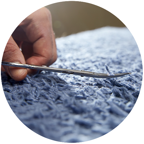 rug being trimmed with scissors